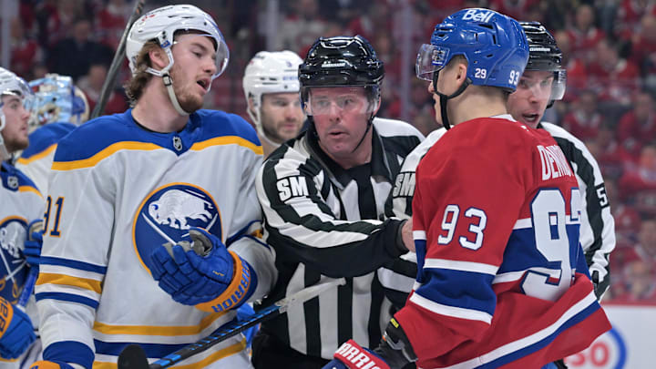 May 12, 2026; Montreal, Quebec, CAN; linesmen Julien Fournier (56) and Matt MacPherson (83) step in between Buffalo Sabres forward Josh Doan (91) and Montreal Canadiens forward Ivan Demidov (93) during the third period in game four of the second round of the 2026 Stanley Cup Playoffs at Bell Centre. Mandatory Credit: Eric Bolte-Imagn Images