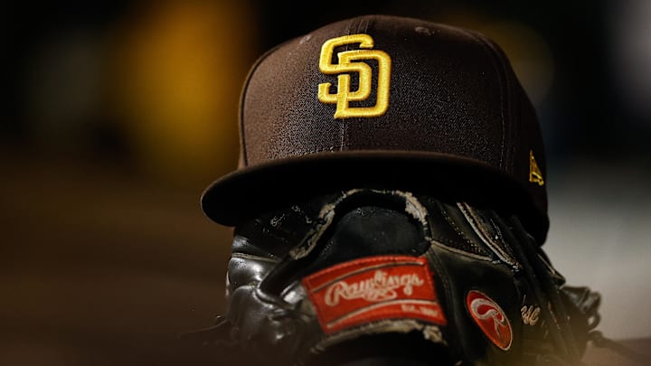 A detail view of a San Diego Padres hat on a glove in the dugout in the ninth inning against the Colorado Rockies at Coors Field on June 17, 2022.