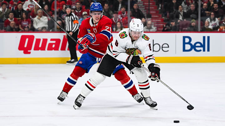 Apr 14, 2025; Montreal, Quebec, CAN; Chicago Blackhawks center Ryan Donato (8) plays the puck against Montreal Canadiens defenseman Kaiden Guhle (21) in the third period at Bell Centre.