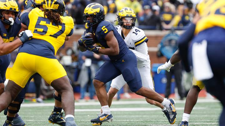 Michigan Wolverines quarterback Tommy Carr hands the ball off to running back Savion Hiter Michigan Wolverines quarterback Tommy Carr hands the ball off to running back Savion Hiter