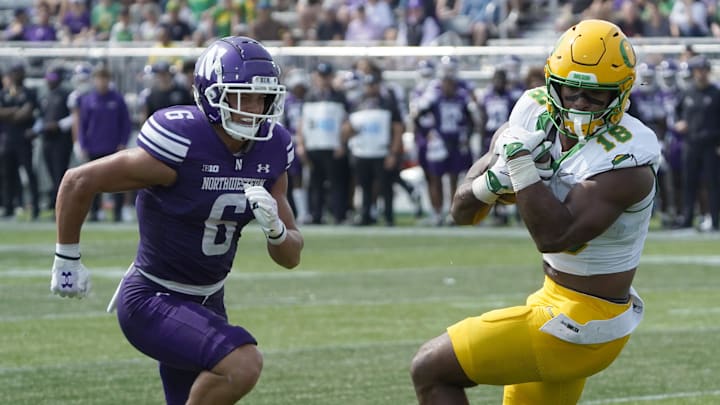Sep 13, 2025; Evanston, Illinois, USA; Oregon Ducks tight end Kenyon Sadiq (18) catches a touchdown pass as Northwestern Wildcats defensive back Robert Fitzgerald (6) defends him during the first half at Northwestern Medicine Field at Martin Stadium. Mandatory Credit: David Banks-Imagn Images