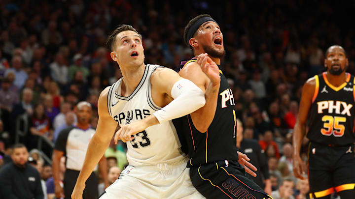 Dec 3, 2024; Phoenix, Arizona, USA; San Antonio Spurs forward Zach Collins (23) against Phoenix Suns guard Devin Booker (1) during an NBA Cup game at Footprint Center.