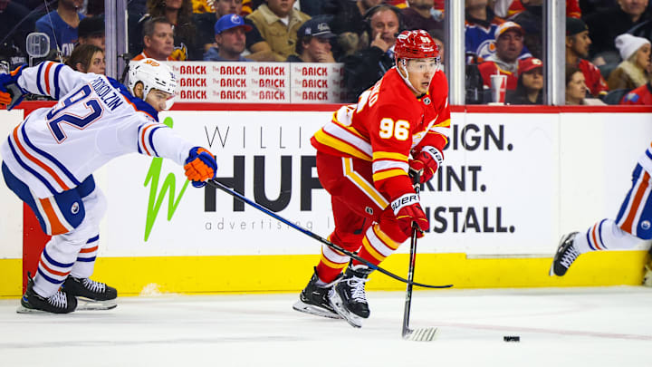 Nov 3, 2024; Calgary, Alberta, CAN; Calgary Flames left wing Andrei Kuzmenko (96) controls the puck against Edmonton Oilers right wing Vasily Podkolzin (92) during the third period at Scotiabank Saddledome. Mandatory Credit: Sergei Belski-Imagn Images