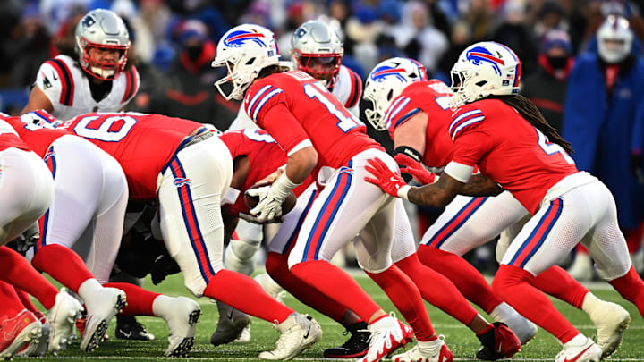Dec 22, 2024; Orchard Park, New York, USA; Buffalo Bills quarterback Josh Allen (17) is pushed by running back James Cook (4) to gain a first down
