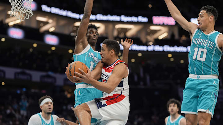 Feb 3, 2025; Charlotte, North Carolina, USA; Washington Wizards guard Malcolm Brogdon (15) at the rim defended by Charlotte Hornets forward Moussa Diabate (14) during the second half at Spectrum Center. Mandatory Credit: Jim Dedmon-Imagn Images