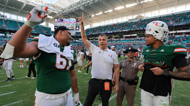 Nov 23, 2024; Miami Gardens, Florida, USA; Miami Hurricanes head coach Mario Cristobal celebrates with Miami Hurricanes offensive lineman Francis Mauigoa (61) and tight end Elijah Arroyo (8) after the game against the Wake Forest Demon Deacons at Hard Rock Stadium. Mandatory Credit: Sam Navarro-Imagn Images