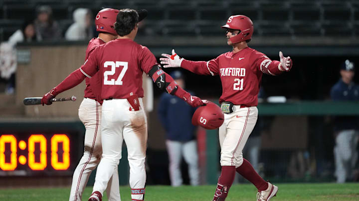 Mar 1, 2025; Stanford, CA, USA; Stanford Cardinal designated hitter Charlie Saum (21) celebrates with right fielder Brady Reynolds (27) and second baseman Jimmy Nati (back left) after hitting a home run against the Xavier Musketeers during the eighth inning at Sunken Diamond. Mandatory Credit: Darren Yamashita-Imagn Images