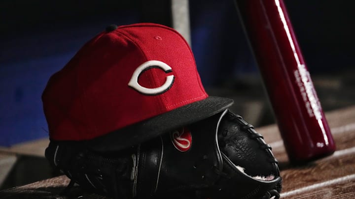 A general view of a Cincinnati Reds cap and glove in the dugout