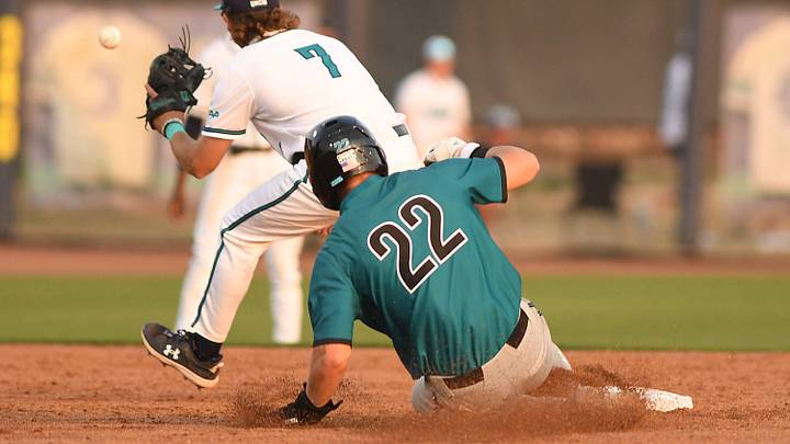 UNCW's #7 Aiden Evans waits for the ball as Coastal's #22 Graham Brown slides safely into 2nd base as UNCW took on Coastal Carolina Tuesday April 2, 2024 at home. UNCW won 6-4. KEN BLEVINS/STARNEWS