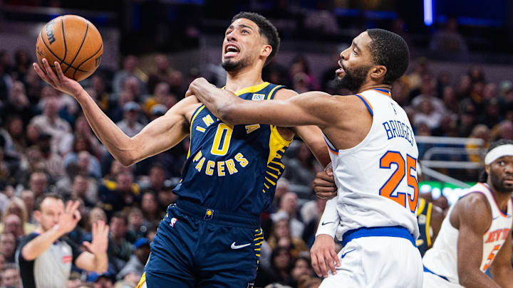 Feb 11, 2025; Indianapolis, Indiana, USA; Indiana Pacers guard Tyrese Haliburton (0) shoots the ball while New York Knicks forward Mikal Bridges (25) defends in the first half at Gainbridge Fieldhouse. Mandatory Credit: Trevor Ruszkowski-Imagn Images