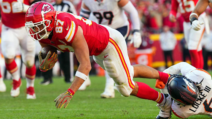 Nov 10, 2024; Kansas City, Missouri, USA; Kansas City Chiefs tight end Travis Kelce (87) is tackled by Denver Broncos safety P.J. Locke (6) during the second half at GEHA Field at Arrowhead Stadium. 