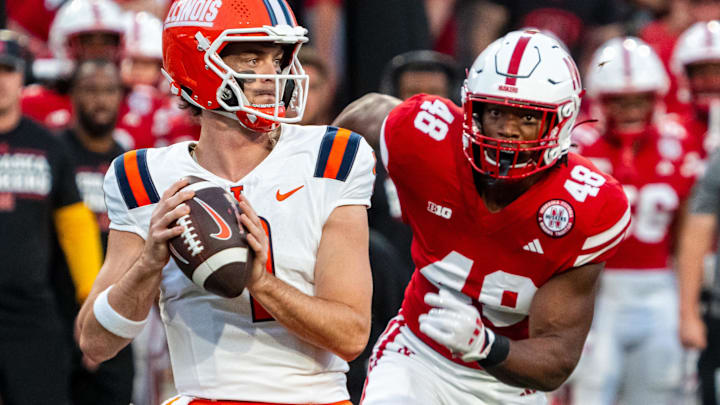 Sep 20, 2024; Lincoln, Nebraska, USA; Illinois Fighting Illini quarterback Luke Altmyer drops to throw against Nebraska Cornhuskers linebacker MJ Sherman during the first quarter at Memorial Stadium.