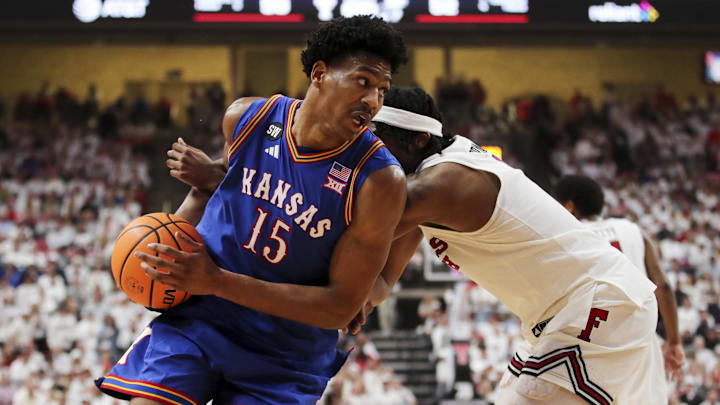 Feb 2, 2026; Lubbock, Texas, USA;  Kansas Jayhawks guard Bryson Tiller (15) drives the ball around Texas Tech Red Raiders guard Tyeree Byran (1) in the second half at United Supermarkets Arena. 
