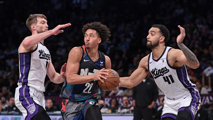 Apr 7, 2024; Brooklyn, New York, USA; Brooklyn Nets forward Jalen Wilson (22) looks to pass as Sacramento Kings center Domantas Sabonis (10) and forward Trey Lyles (41) defend him. 