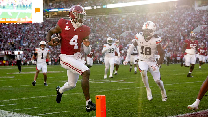 Nov 30, 2024; Tuscaloosa, Alabama, USA; Alabama Crimson Tide quarterback Jalen Milroe (4) runs for a touchdown against Auburn safety Kaleb Harris (18) during the first half at Bryant-Denny Stadium. Mandatory Credit: Gary Cosby Jr.-Imagn Images Nov 30, 2024; Tuscaloosa, Alabama, USA; Alabama Crimson Tide quarterback Jalen Milroe (4) runs for a touchdown against Auburn safety Kaleb Harris (18) during the first half at Bryant-Denny Stadium. Mandatory Credit: Gary Cosby Jr.-Imagn Images