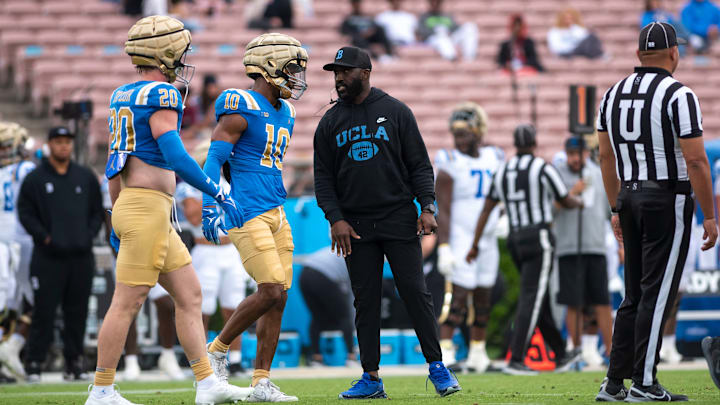 Coach DeShaun Foster talks to redshirt junior defensive back Ben Perry and incoming freshman defensive lineman Scott Taylor at the Rose Bowl. UCLA football hosted its annual spring showcase Saturday afternoon. (Max Zhang/Daily Bruin)