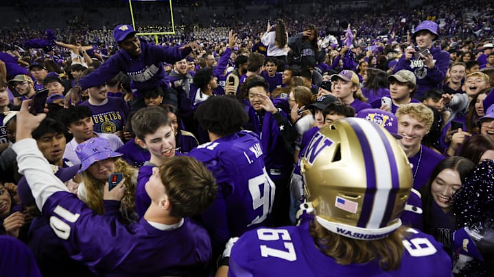 Oct 5, 2024; Seattle, Washington, USA; Washington Huskies fans rush the field to congratulate players following a victory against the Michigan Wolverines at Alaska Airlines Field at Husky Stadium. Mandatory Credit: Joe Nicholson-Imagn Images
