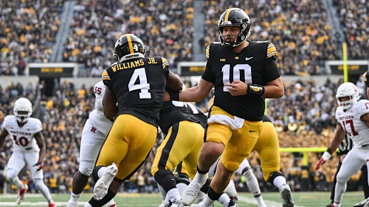 Nov 11, 2023; Iowa City, Iowa, USA; Iowa Hawkeyes quarterback Deacon Hill (10) hands the ball off to running back Leshon Williams (4) against the Rutgers Scarlet Knights during the first quarter at Kinnick Stadium. Nov 11, 2023; Iowa City, Iowa, USA; Iowa Hawkeyes quarterback Deacon Hill (10) hands the ball off to running back Leshon Williams (4) against the Rutgers Scarlet Knights during the first quarter at Kinnick Stadium.
