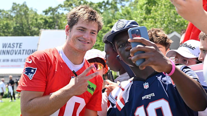 Jul 23, 2025; Foxborough, MA, USA; New England Patriots quarterback Drake Maye (10) takes a selfie with a fan after practice during day one of training camp at Gillette Stadium. Mandatory Credit: Eric Canha-Imagn Images