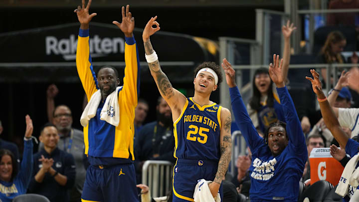 Feb 23, 2024; San Francisco, California, USA; Golden State Warriors forward Draymond Green (left) and guard Lester Quinones (25) gesture after a three point basket by guard Klay Thompson (not pictured) during the fourth quarter against the Charlotte Hornets at Chase Center. Mandatory Credit: Darren Yamashita-Imagn Images