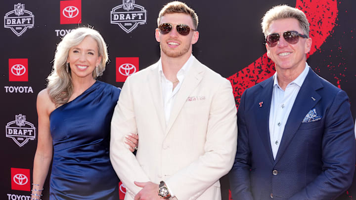 Dillon Thieneman poses with his parents Ken and Shannon Thieneman on the red carpet before the 2026 NFL Draft.