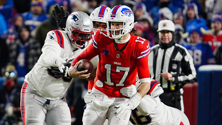 Buffalo Bills quarterback Josh Allen avoids New England Patriots Daniel Ekuale and breaks Jeremiah Pharms Jr. 's attempted tackle to gain several yards on a carry during first half action at Highmark Stadium