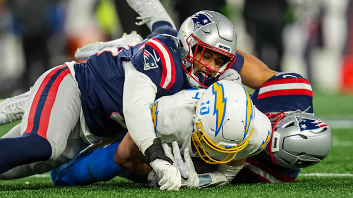 Jan 11, 2026; Foxborough, MA, USA; New England Patriots linebacker Elijah Ponder (91) and linebacker Christian Elliss (53) take down Los Angeles Chargers quarterback Justin Herbert (10) during the second half in an AFC Wild Card Round game at Gillette Stadium. Mandatory Credit: David Butler II-Imagn Images