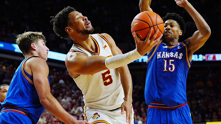 Iowa State Cyclones forward Joshua Jefferson (5) goes for a layup between Kansas Jayhawks guard Kohl Rosario (7) and forward Bryson Tiller (15) during the second half in the Big-12 conference basketball showdown on Feb. 14, 2026, at Hilton Coliseum, in Ames, Iowa.