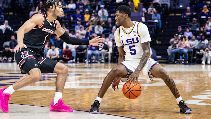 Feb 18, 2025; Baton Rouge, Louisiana, USA;  LSU Tigers guard Cam Carter (5) dribbles against South Carolina Gamecocks guard Jacobi Wright (1) during the first half at Pete Maravich Assembly Center. Mandatory Credit: Stephen Lew-Imagn Images