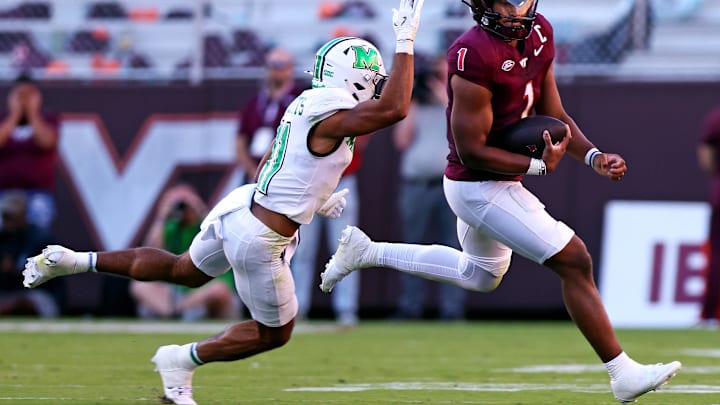 Sep 7, 2024; Blacksburg, Virginia, USA; Virginia Tech Hokies quarterback Kyron Drones (1) scrambles out of the pocket against Marshall Thundering Herd defensive back J.J. Roberts (11) during the second quarter at Lane Stadium. Mandatory Credit: Peter Casey-Imagn Images