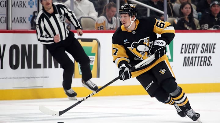 Nov 27, 2024; Pittsburgh, Pennsylvania, USA;  Pittsburgh Penguins right wing Rickard Rakell (67) skates with the puck against the Vancouver Canucks during the third period at PPG Paints Arena. Mandatory Credit: Charles LeClaire-Imagn Images