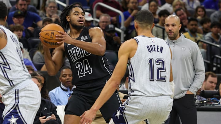 Dec 29, 2024; Orlando, Florida, USA; Brooklyn Nets guard Cam Thomas (24) looks to pass in front of Orlando Magic guard Trevelin Queen (12) during the second quarter at Kia Center. Mandatory Credit: Mike Watters-Imagn Images