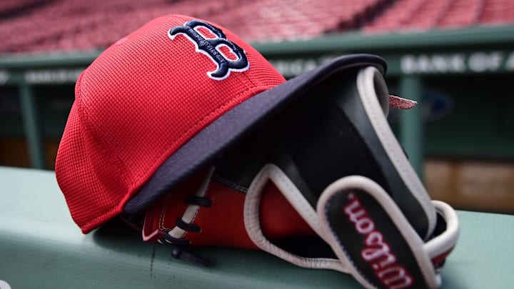 May 18, 2025; Boston, Massachusetts, USA;  A Boston Red Sox hat and glove rests on the railing by the dugout prior to a game against the Atlanta Braves at Fenway Park. Mandatory Credit: Bob DeChiara-Imagn Images