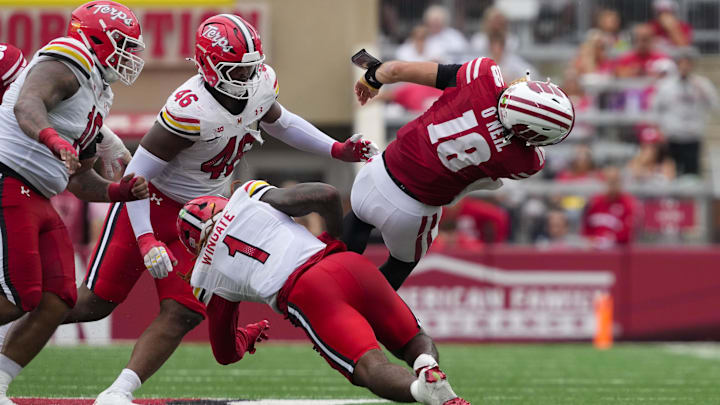 Sep 20, 2025; Madison, Wisconsin, USA;  Wisconsin Badgers quarterback Danny O'Neil (18) is tackled by Maryland Terrapins linebacker Daniel Wingate (1) during the third quarter at Camp Randall Stadium. Mandatory Credit: Jeff Hanisch-Imagn Images