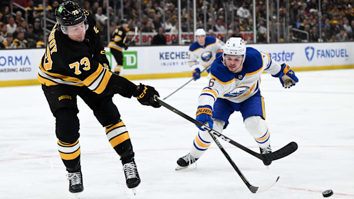 Apr 23, 2026; Boston, Massachusetts, USA; Boston Bruins defenseman Charlie McAvoy (73) clears the puck against Buffalo Sabres left wing Zach Benson (6) during the second period of game three of the first round of the 2026 Stanley Cup Playoffs at the TD Garden. Mandatory Credit: Brian Fluharty-Imagn Images