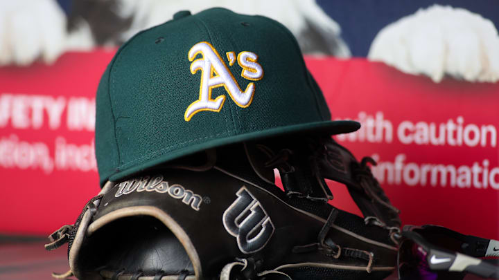 Jun 1, 2024; Atlanta, Georgia, USA; A detailed view of an Oakland Athletics hat and glove on the field against the Atlanta Braves in the sixth inning at Truist Park. Mandatory Credit: Brett Davis-Imagn Images