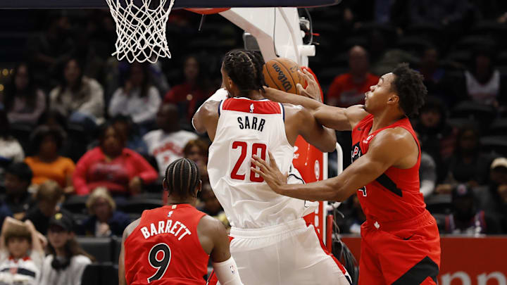 Oct 12, 2025; Washington, District of Columbia, USA; Washington Wizards center Alex Sarr (20) is fouled while shooting by Toronto Raptors forward/guard Scottie Barnes (4) in the first half at Capital One Arena. Mandatory Credit: Geoff Burke-Imagn Images