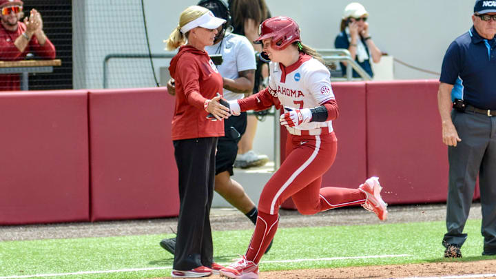 Oklahoma outfielder Kasidi Pickering high-fives coach Patty Gasso after hitting a home run against Binghamton.