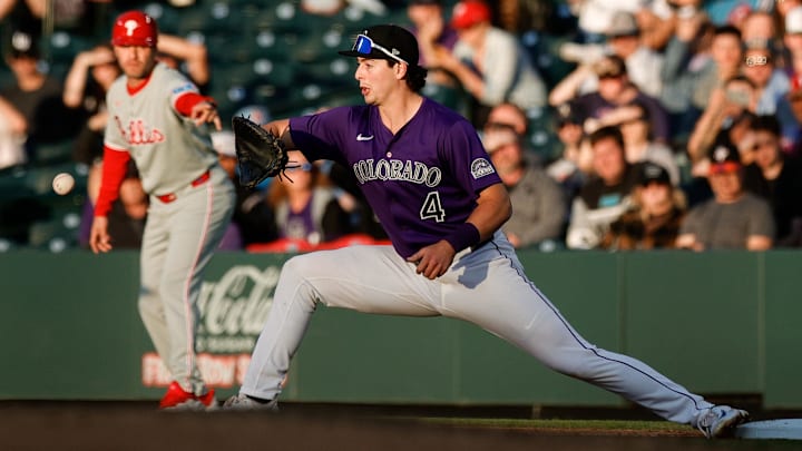 May 20, 2025; Denver, Colorado, USA; Colorado Rockies first baseman Michael Toglia (4) fields a throw for an out in the fourth inning against the Philadelphia Phillies at Coors Field.