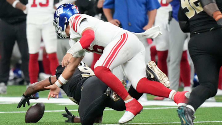 Oct 5, 2025; New Orleans, Louisiana, USA; New Orleans Saints defensive end Cameron Jordan (94) recovers a fumble in front of New York Giants quarterback Jaxson Dart (6) during the third quarter at Caesars Superdome.  