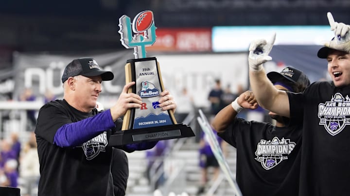 Dec 26, 2024; Phoenix, AZ, USA; Kansas State Wildcats head coach Chris Klieman celebrates with the trophy after defeating the Rutgers Scarlet Knights during the Rate Bowl at Chase Field. Mandatory Credit: Mark J. Rebilas-Imagn Images