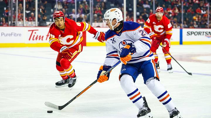 Sep 21, 2025; Calgary, Alberta, CAN; Edmonton Oilers right wing Quinn Hutson (28) controls the puck against the Calgary Flames during the first period at Scotiabank Saddledome. Mandatory Credit: Sergei Belski-Imagn Images