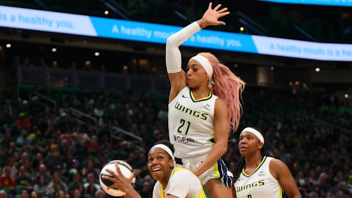 Jun 3, 2025; Seattle, Washington, USA; Dallas Wings guard DiJonai Carrington (21) jumps over Seattle Storm center Dominique Malonga (14) during the first half at Climate Pledge Arena. Mandatory Credit: Steven Bisig-Imagn Images