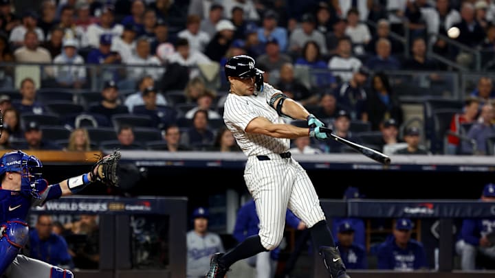 Oct 30, 2024; New York, New York, USA; New York Yankees designated hitter Giancarlo Stanton (27) hits a home run during the third inning against the Los Angeles Dodgers in game five of the 2024 MLB World Series at Yankee Stadium.