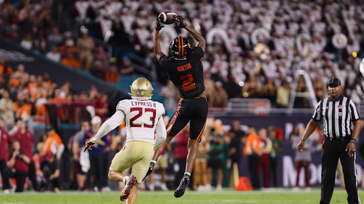 Oct 26, 2024; Miami Gardens, Florida, USA; Miami Hurricanes wide receiver Isaiah Horton (2) cst chef the football against Florida State Seminoles defensive back Fentrell Cypress II (23) during the second quarter at Hard Rock Stadium. Mandatory Credit: Sam Navarro-Imagn Images