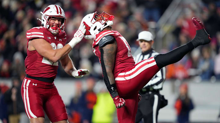 Wisconsin Badgers linebacker Mason Reiger, left, and Wisconsin Badgers linebacker Darryl Peterson, right, react to sacking Illinois Fighting Illini quarterback Luke Altmyer (not pictured) during the second half at Camp Randall Stadium. 