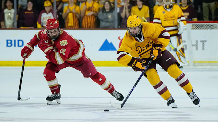 Sam Harris (12) of the Denver Pioneers follows Cruz Lucius (51) of the Arizona State Sun Devils down the ice as they play 3-on-3 in overtime at Mullett Arena on Feb. 8, 2025, in Tempe, Ariz.