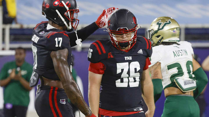 Nov 1, 2024; Boca Raton, Florida, USA;  Florida Atlantic Owls tight end Wyatt Sullivan (17) consoles place kicker Carter Davis (36) after missing a field goal as South Florida Bulls cornerback Brent Austin (20) walks off during the second quarter at FAU Stadium. Mandatory Credit: Reinhold Matay-Imagn Images