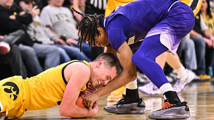  Iowa forward Payton Sandfort (20) and Huskies guard Tyler Harris (8) battle for a loose ball.
