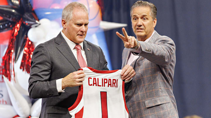 University of Arkansas Athletic Director holds up a No. 1 Razorback basketball jersey during the introductory press conference for John Calipari last spring. 